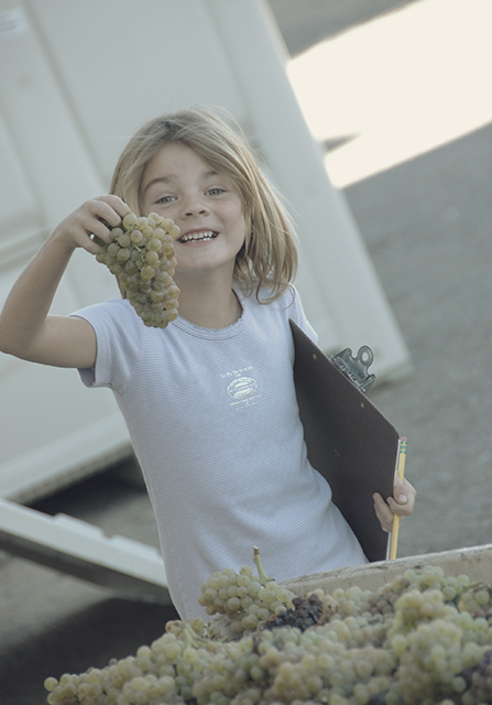 Estelle holding a cluster of grapes